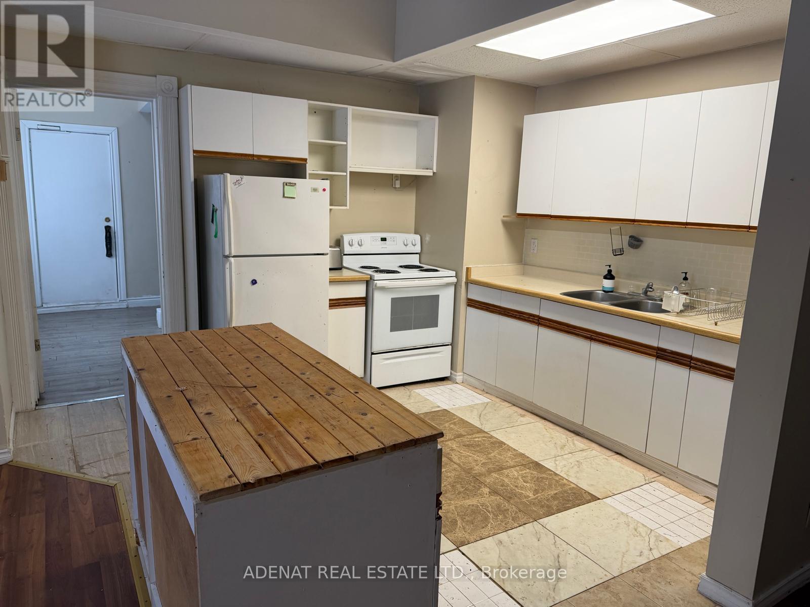 A kitchen with white appliances and wooden countertops.