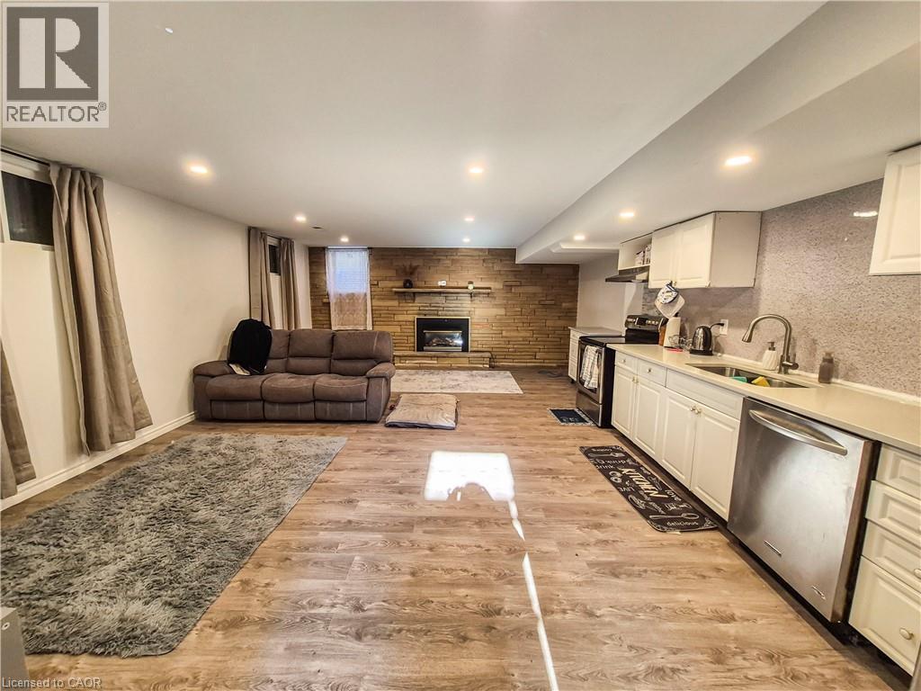 A well-lit living room with a brown sofa and a fireplace.