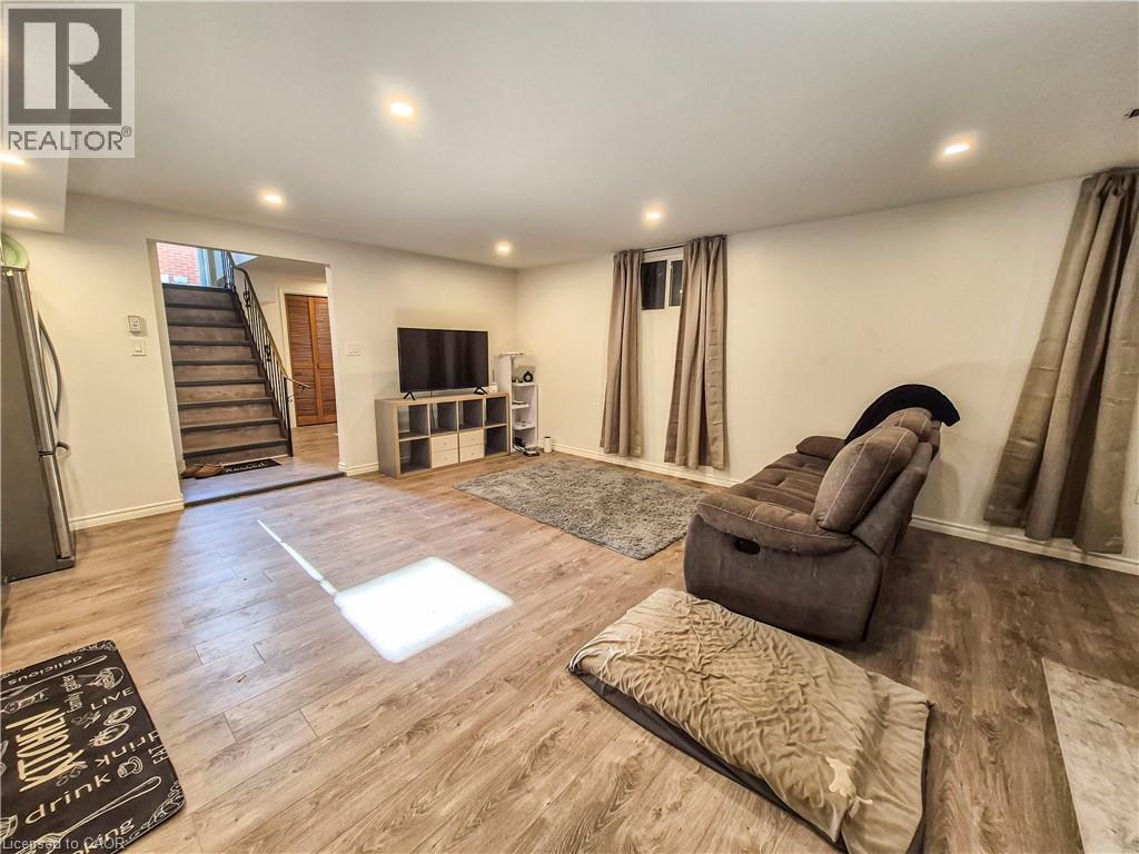 A living room with a brown sofa and a wooden floor.