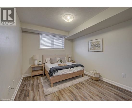 A bedroom with a bed, nightstands, and a rug.
