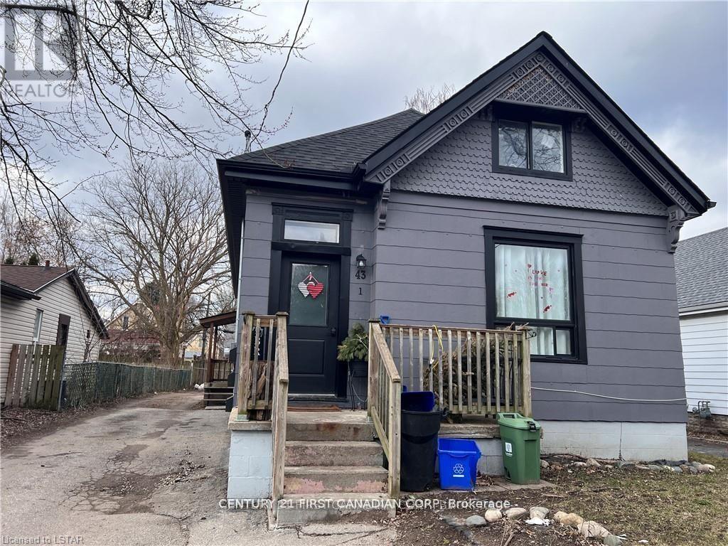 A grey house with a black door and windows.