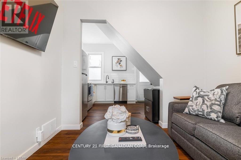 A living room with a grey couch and a coffee table in front of a staircase.