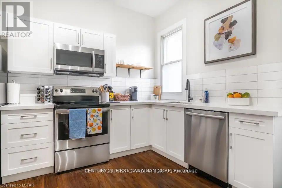 A kitchen with white cabinets and a stainless steel oven.