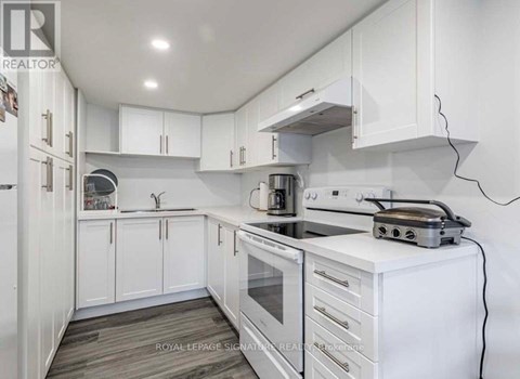 A white kitchen with a stove and cabinets.