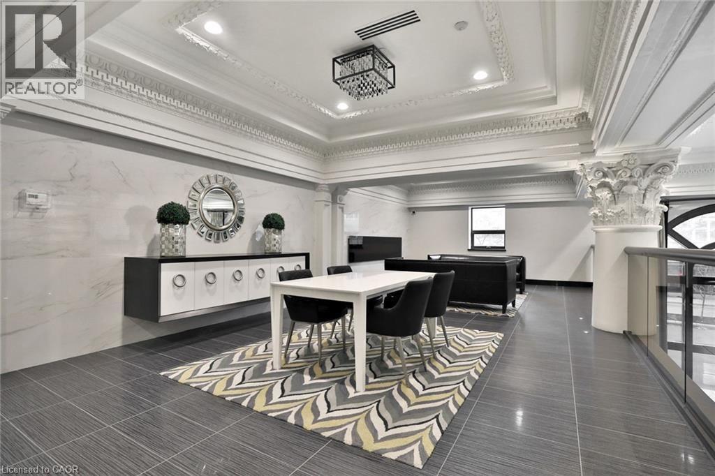 A well-lit, spacious dining area with a marble floor and a large mirror on the wall.