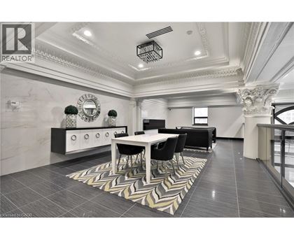 A well-lit, spacious dining area with a marble floor and a large mirror on the wall.