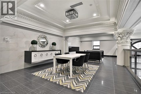 A well-lit, spacious dining area with a marble floor and a large mirror on the wall.