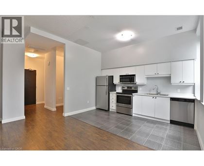 A kitchen with white cabinets and a black fridge.