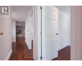 A hallway with a white door and a wooden floor.