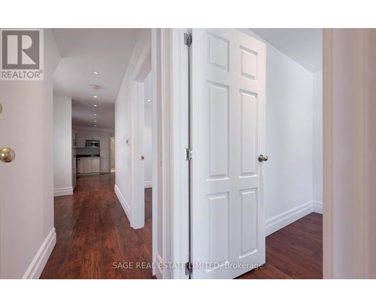 A hallway with a white door and a wooden floor.
