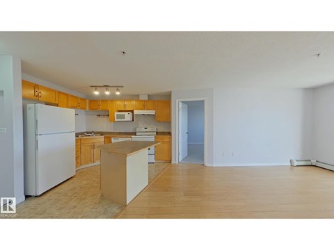 A kitchen with wooden cabinets and a white refrigerator.