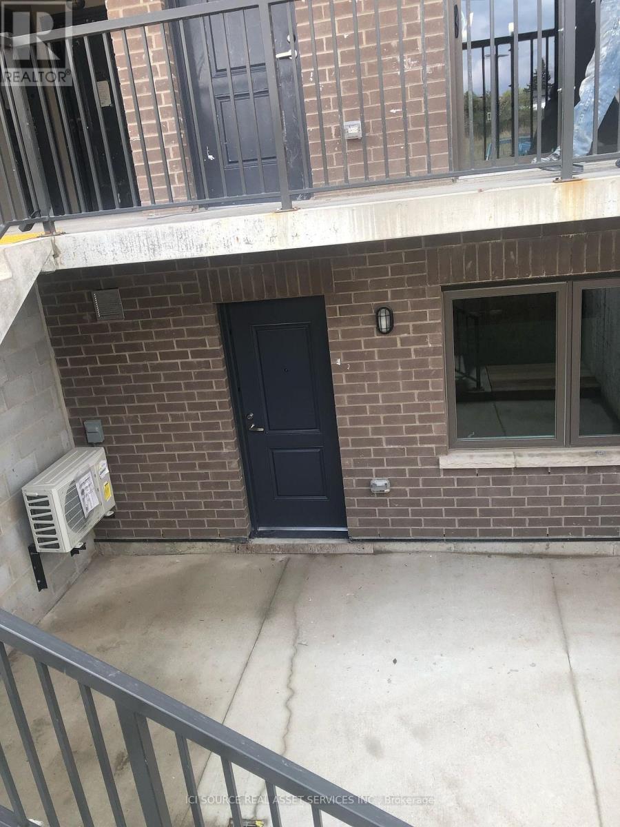 A black door is on the side of a brick building.