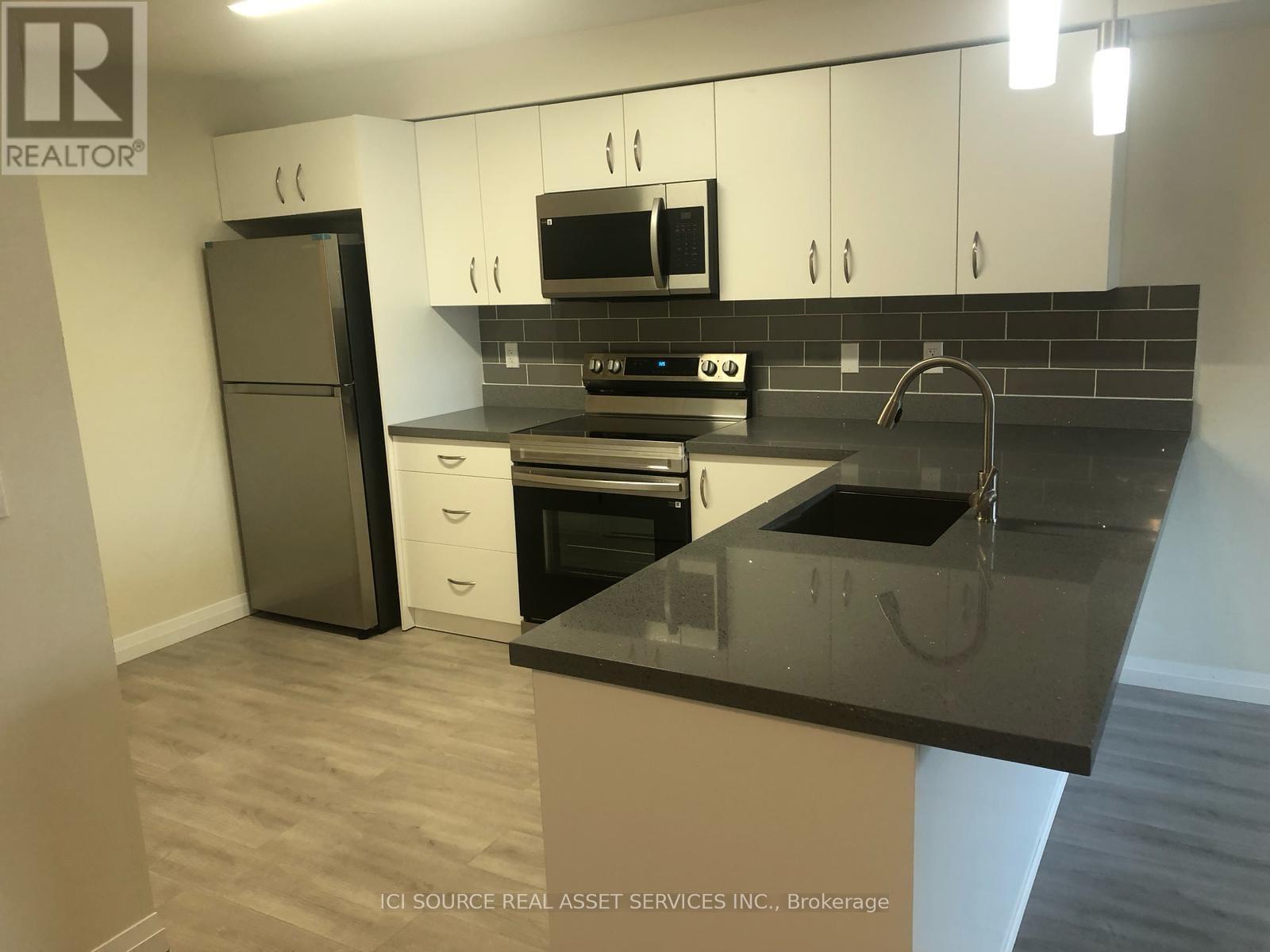 A kitchen with a black counter top and white cabinets.