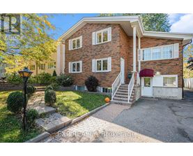 A house with a brick facade and a red awning is for sale.