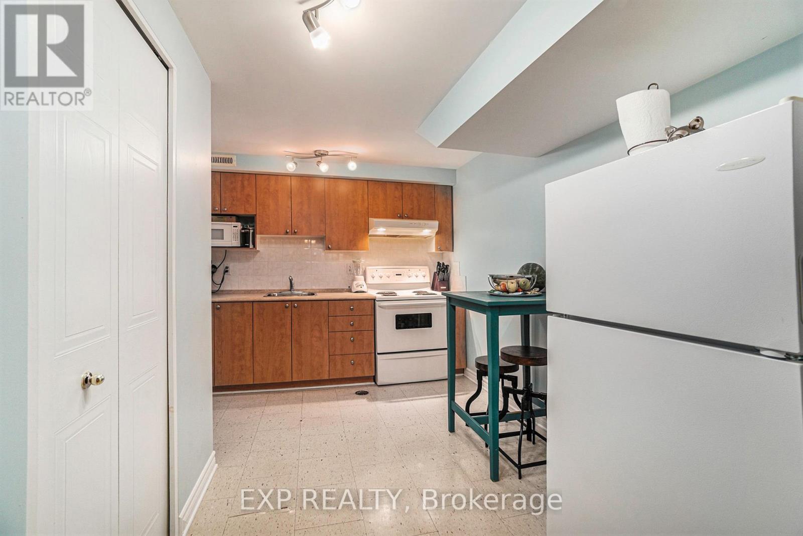 A kitchen with wooden cabinets and a white refrigerator.