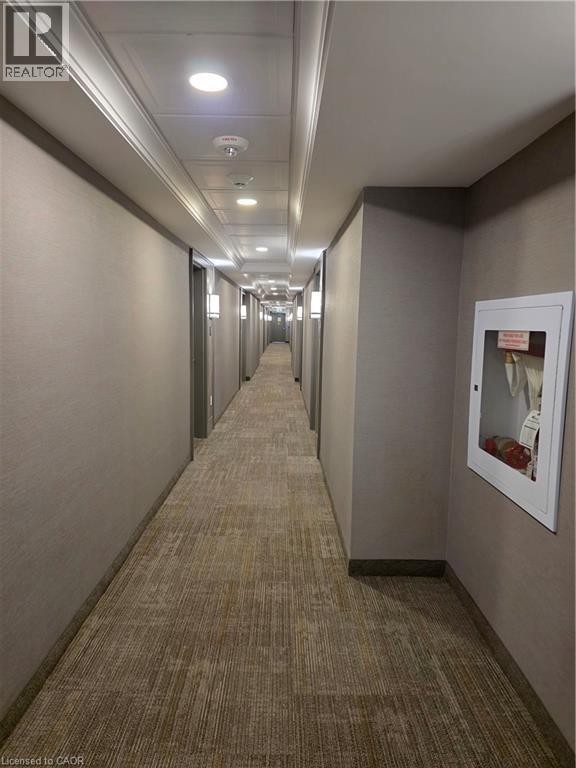 A long hallway with carpeted floors and white walls.