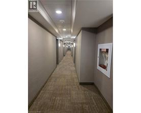 A long hallway with carpeted floors and white walls.