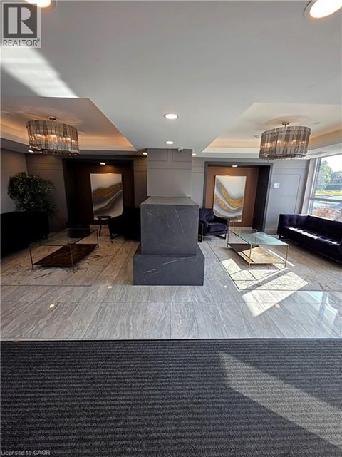 A well-lit, modern living room with a grey sofa and a wooden floor.