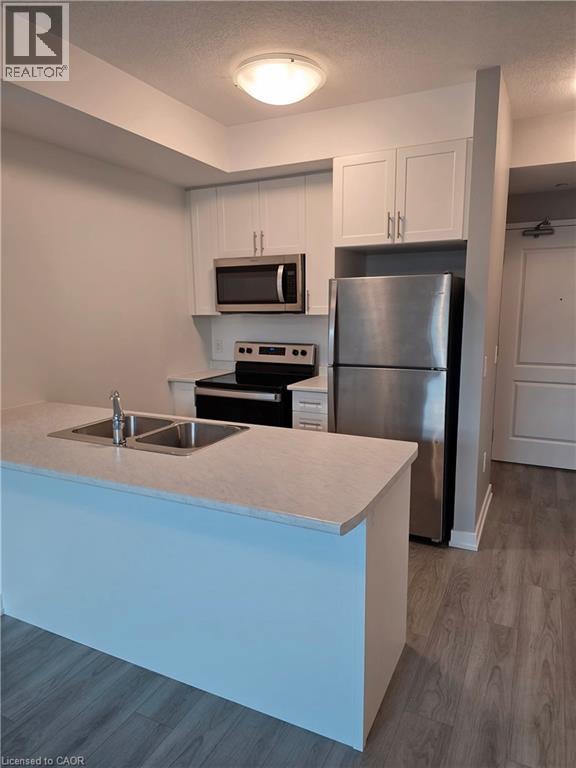 A kitchen with a stainless steel refrigerator and a white countertop.