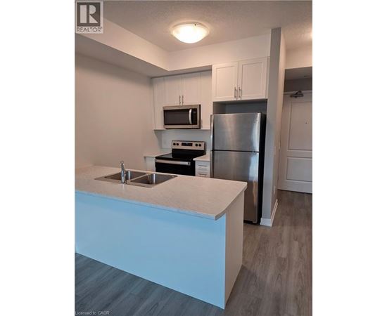 A kitchen with a stainless steel refrigerator and a white countertop.