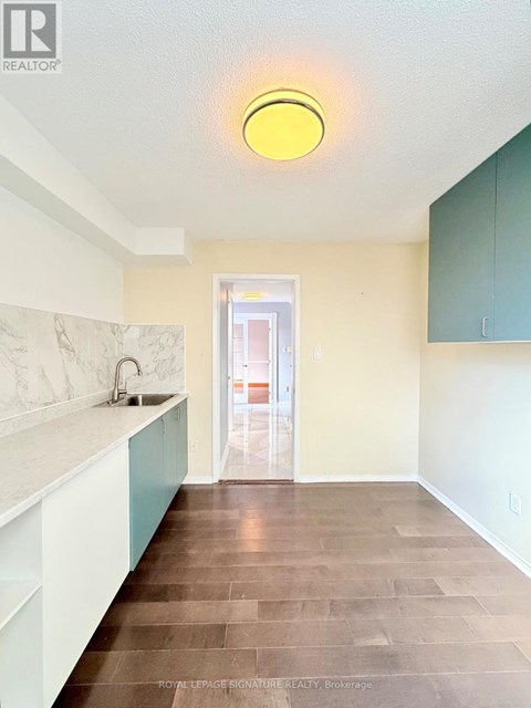 A kitchen with a sink and a yellow ceiling light.
