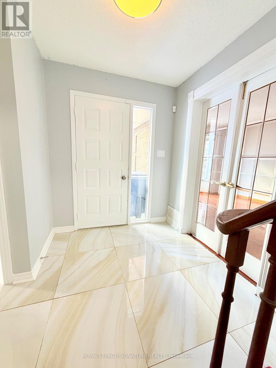 A hallway with a white door and a wooden staircase.