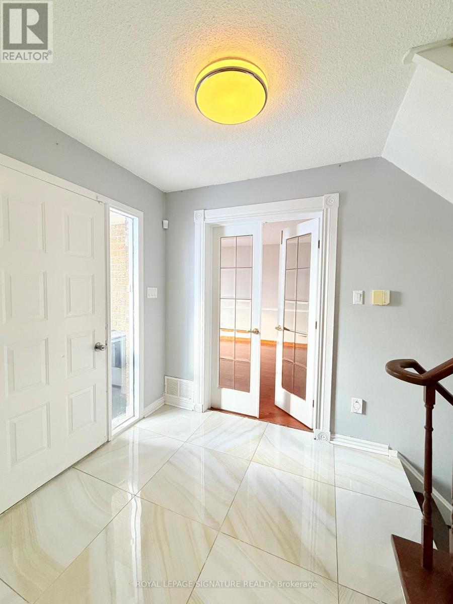 A hallway with a white door and a glass door leading to a balcony.