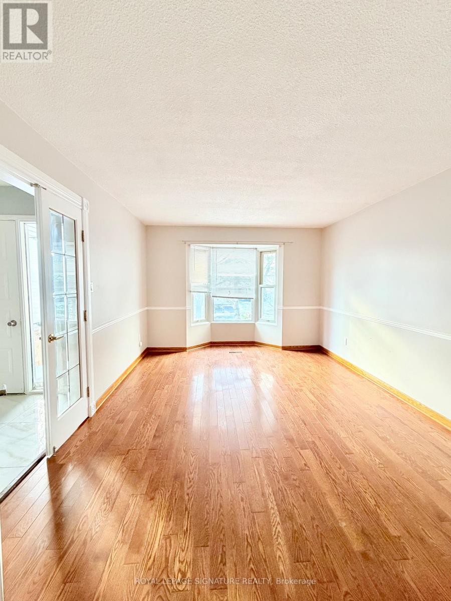 A room with wooden floors and a large window.