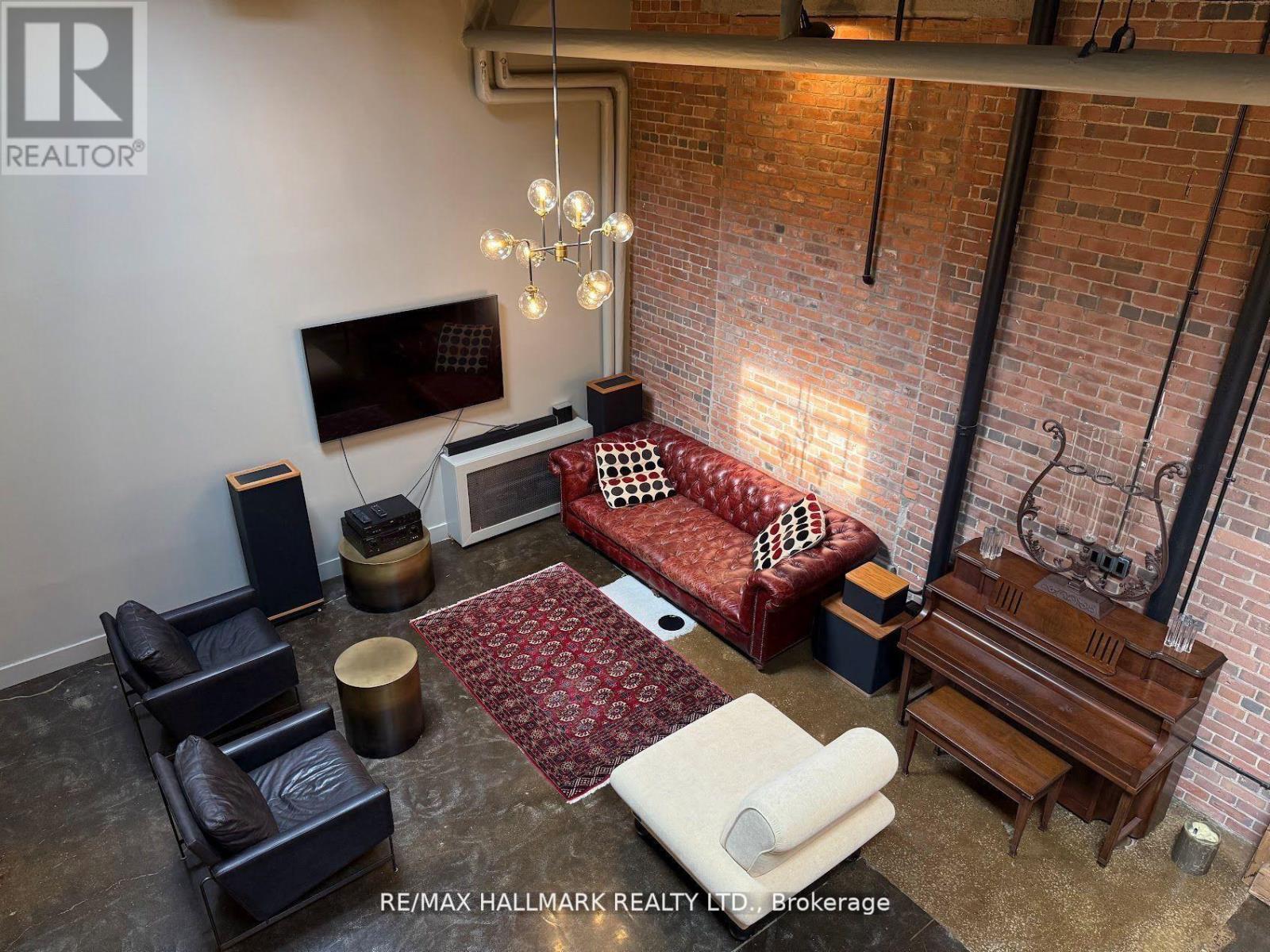 A living room with a red couch and a television on the wall.