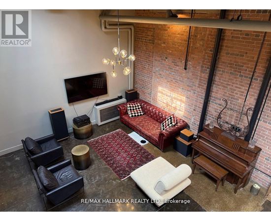 A living room with a red couch and a television on the wall.