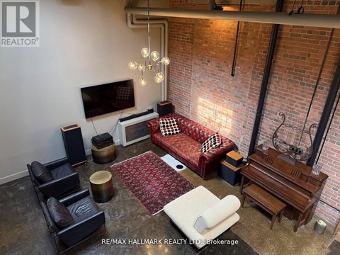 A living room with a red couch and a television on the wall.