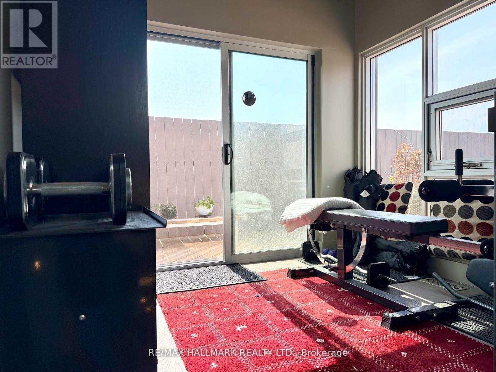 A gym room with a red rug and a treadmill.