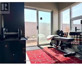 A gym room with a red rug and a treadmill.