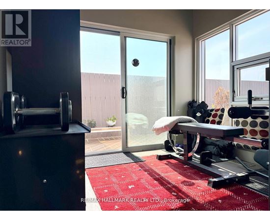 A gym room with a red rug and a treadmill.