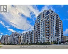 A large apartment building with a clear blue sky and some clouds in the background.
