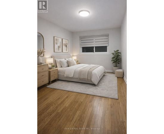A bedroom with a large bed, a nightstand, and a plant.