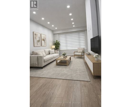 A modern living room with a white couch, a wooden coffee table, and a flat-screen TV mounted on the wall.