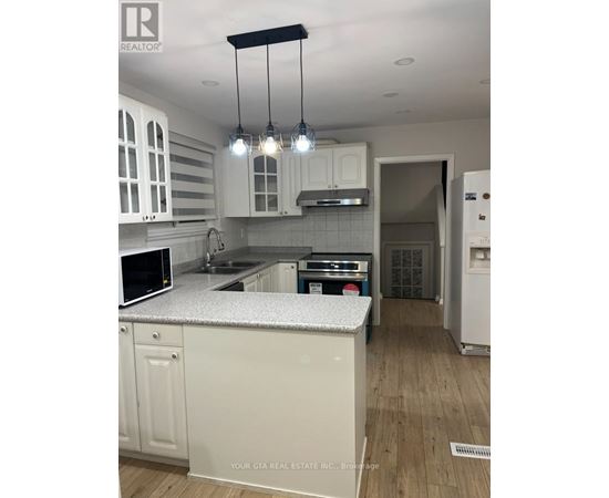 A kitchen with white cabinets and a granite countertop.