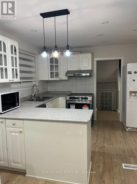 A kitchen with white cabinets and a granite countertop.