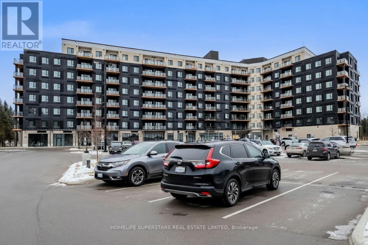A black and white apartment building with cars parked in front.