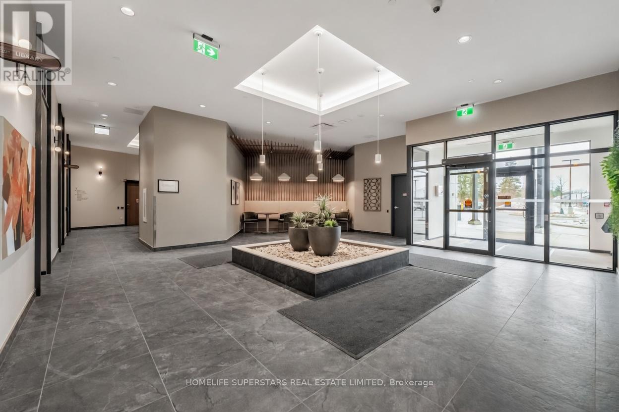 A spacious lobby with a large planter in the center and a reception desk to the left.