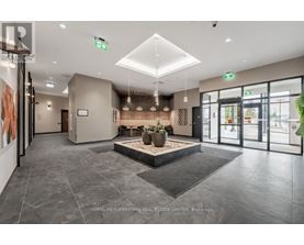 A spacious lobby with a large planter in the center and a reception desk to the left.