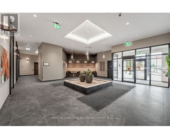 A spacious lobby with a large planter in the center and a reception desk to the left.