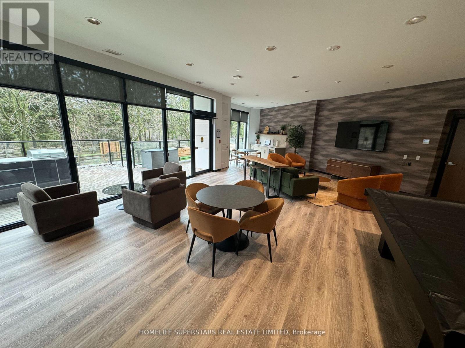 A living room with a wooden floor and a large window.