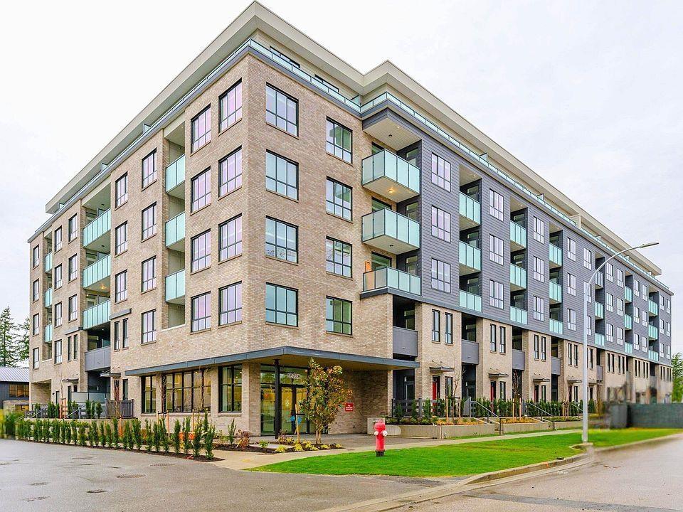 A large, modern apartment building with a fire hydrant in front.