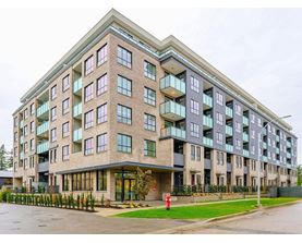 A large, modern apartment building with a fire hydrant in front.