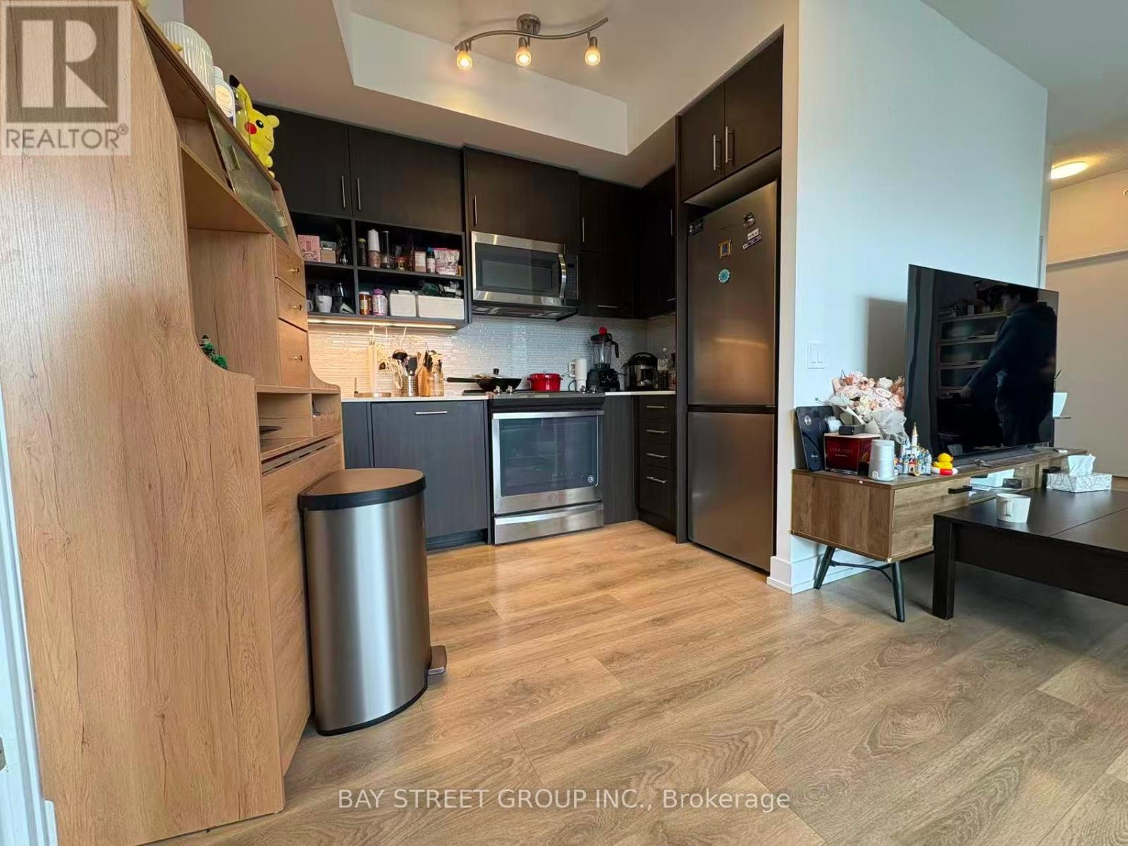 A modern kitchen with wooden cabinets and stainless steel appliances.