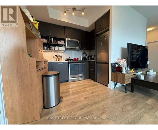 A modern kitchen with wooden cabinets and stainless steel appliances.