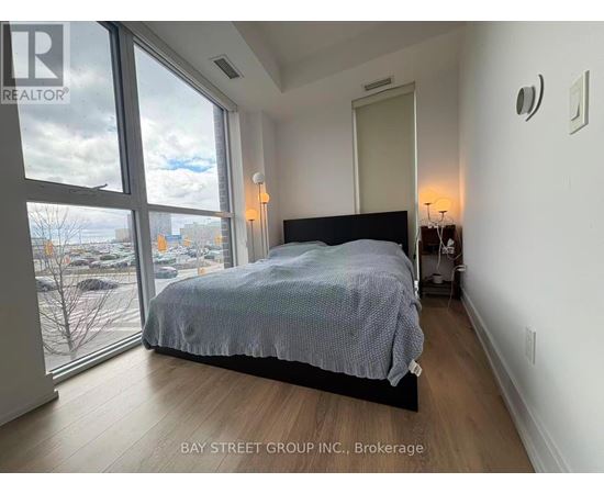 A bedroom with a large bed and a view of the city through the window.