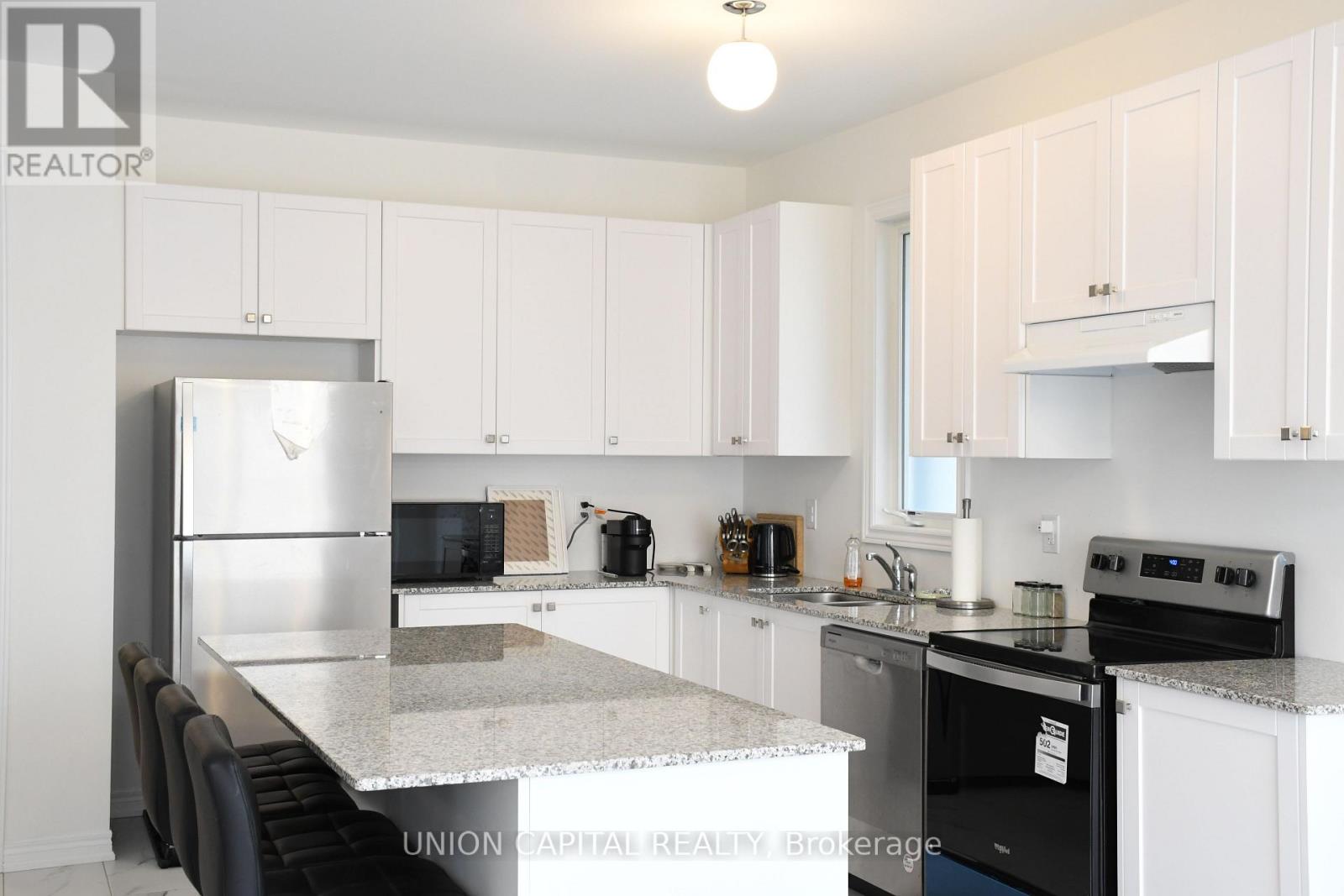 A kitchen with white cabinets and a black stove top oven.